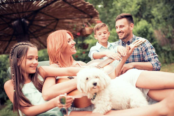 Mother playing guitar for family — Stock Photo, Image