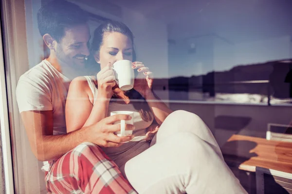 couple drinking coffee by window