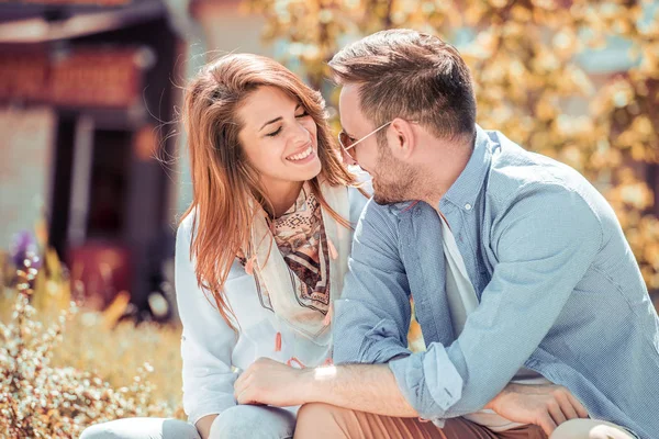 Couple assis à l'extérieur et souriant — Photo