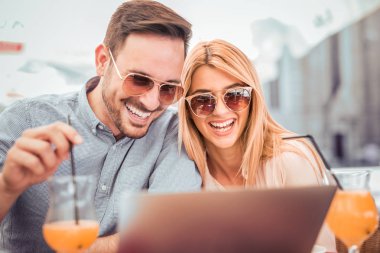 Dizüstü bilgisayar ile kafede oturan Çift