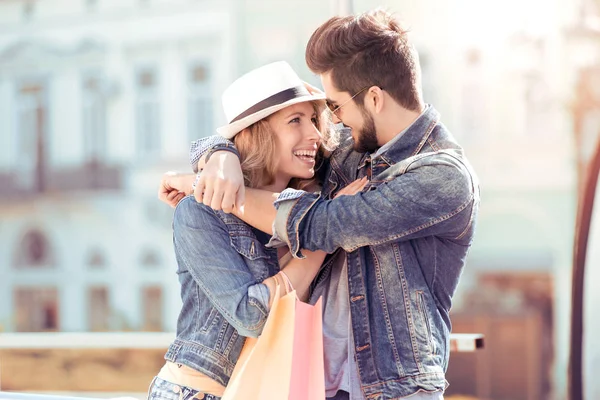 Pareja joven con bolsas de compras sonriendo — Foto de Stock