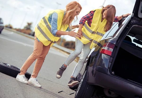 Femmes changer de roue en voiture cassée — Photo