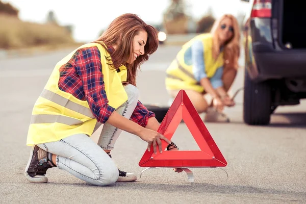 Woman placing road sign on asphalt — Stock Photo, Image