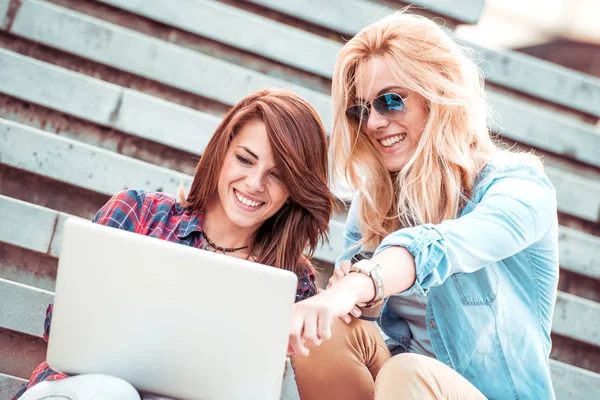 Merdivenlerde dizüstü kullanarak kızlar