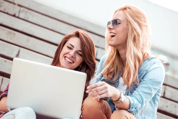 Merdivenlerde dizüstü kullanarak kızlar