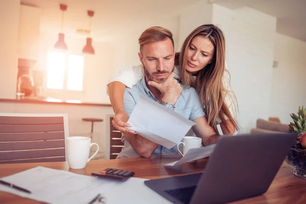 Pareja joven mirando facturas — Foto de Stock