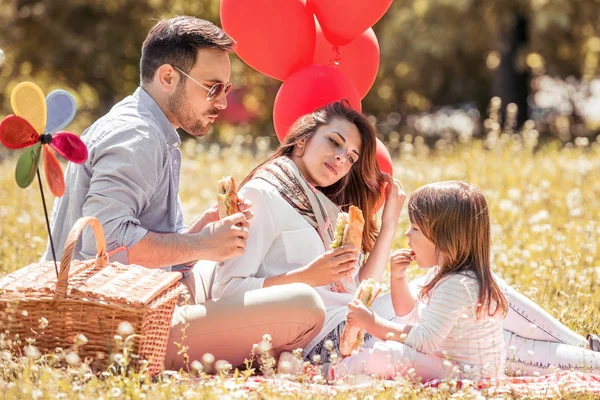 Familia comiendo sándwiches en el picnic — Foto de Stock