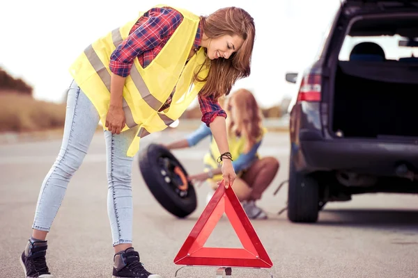 Κορίτσια αλλαγή τροχού σε σπασμένο αυτοκίνητο — Φωτογραφία Αρχείου