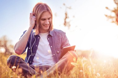 Tablet ve kulaklıklar kullanan adam