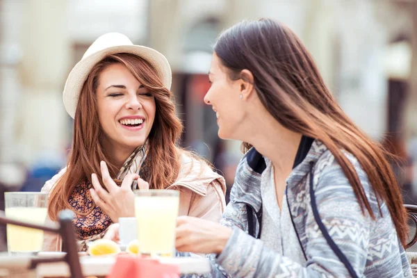 Twee mooie jonge meisjes zitten in een cafe — Stockfoto