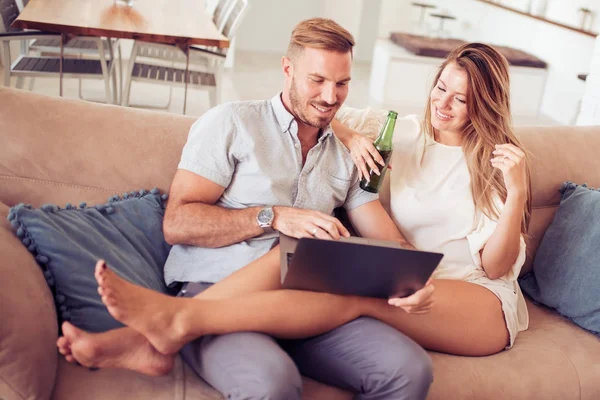 Paar benutzt Laptop auf Couch — Stockfoto