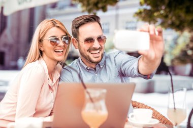Couple taking selfie with smartphone clipart