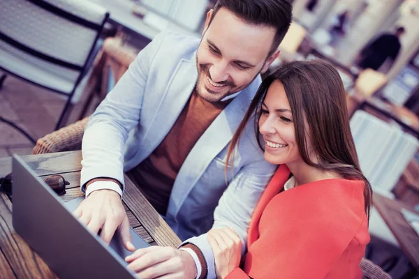 Ehepaar benutzt Laptop in Straßencafé — Stockfoto