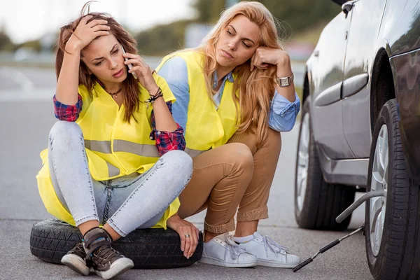Meninas na estrada tentando consertar o carro — Fotografia de Stock
