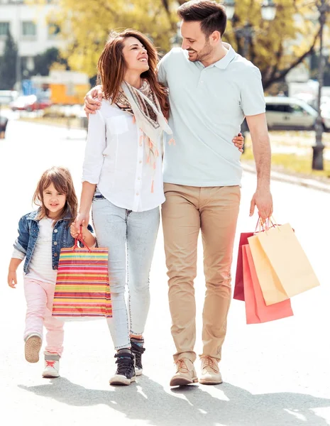 Familjen promenader med kassar och påsar — Stockfoto