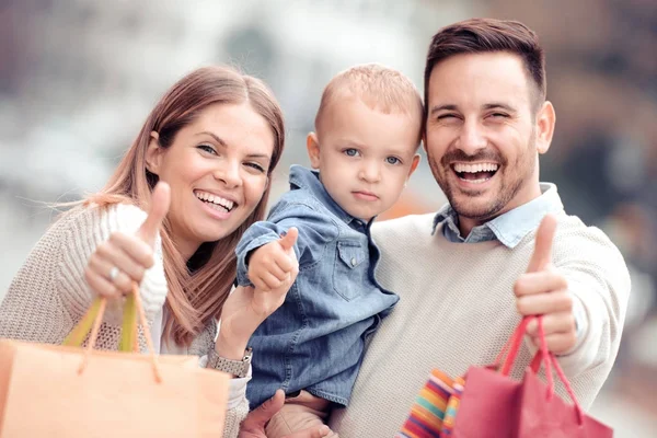 Happy family with shopping bags — Stock Photo, Image