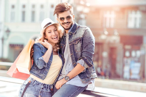 Heureux jeune couple avec des sacs dans la rue de la ville . — Photo