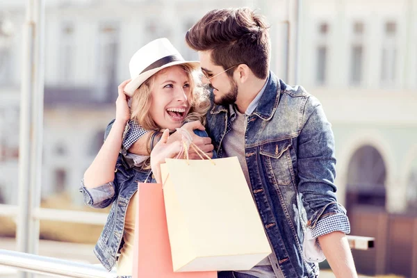 Feliz joven pareja abrazada en la ciudad después de ir de compras . — Foto de Stock