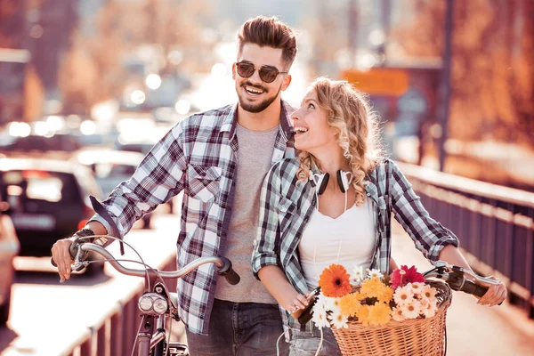 Jonge man en vrouw met fiets op de brug. — Stockfoto
