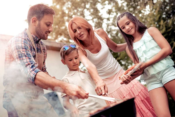 Familia almorzando en su jardín en verano. — Foto de Stock