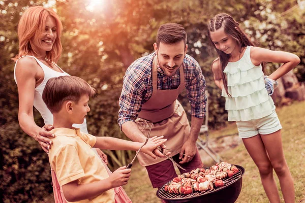 Family having a lunch in their garden in summer. — Stock Photo, Image