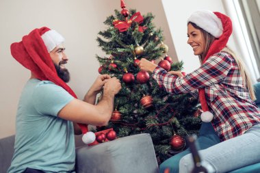 Genç çift bir Noel ağacı süsleme