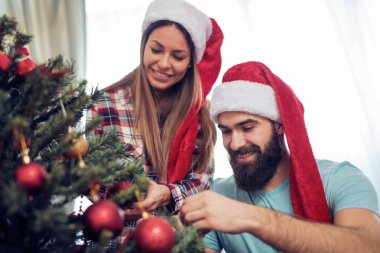 Mutlu çift evlerinde Noel ağacı süslüyorlar.