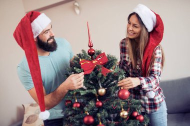 Genç çift bir Noel ağacı süsleme