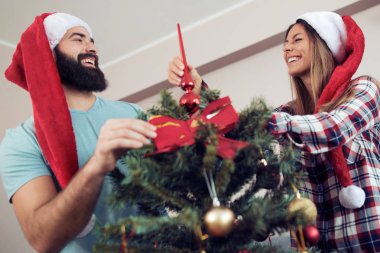 Mutlu çift evlerinde Noel ağacı süslüyorlar.