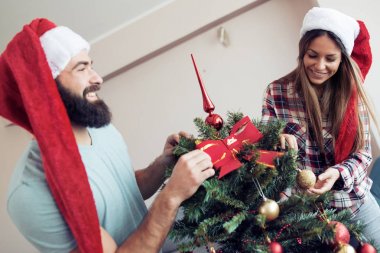 Genç çift bir Noel ağacı süsleme