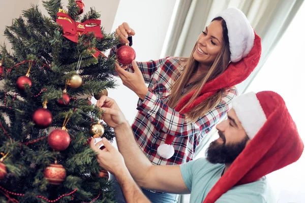 크리스마스 트리를 장식 하는 젊은 부부 — 스톡 사진