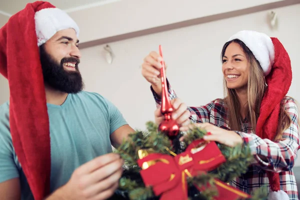 Happy couple decorating Christmas tree in their home — Stock Photo, Image