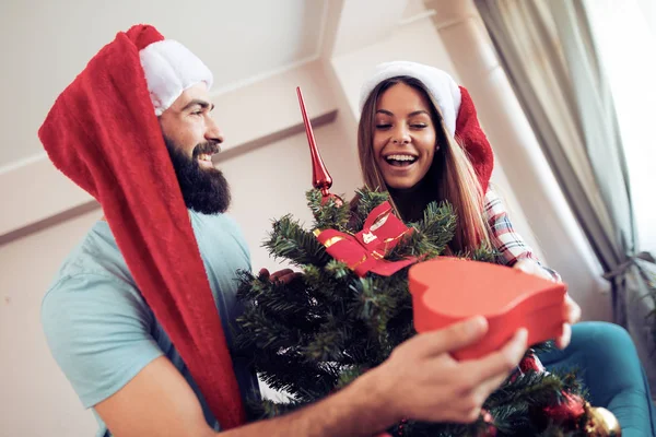 젊은 남자가 그의 여자 친구에 게 크리스마스 선물을 주는 — 스톡 사진