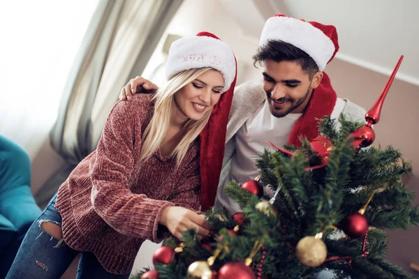 크리스마스 트리를 장식 하는 젊은 부부 — 스톡 사진