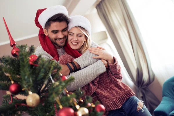 Feliz pareja decorando el árbol de Navidad en su casa —  Fotos de Stock