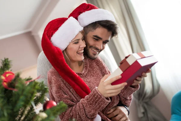 Pareja intercambiando regalos por árbol de Navidad —  Fotos de Stock
