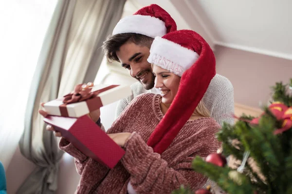 Joven hombre dando a su novia regalo de Navidad —  Fotos de Stock
