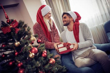 Genç adam kız arkadaşı Noel hediye veriyor