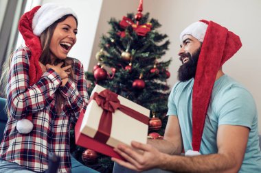 Genç adam kız arkadaşı Noel hediye veriyor