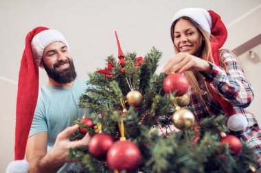 Genç çift bir Noel ağacı süsleme
