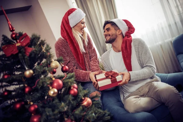 Joven hombre dando a su novia regalo de Navidad —  Fotos de Stock