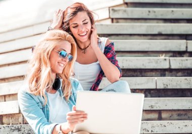 Online PC açık havada şehirde kullanan genç öğrenciler. Teknoloji ve dostluk kavramı.