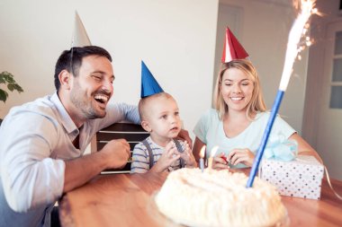 Mutlu bir aile. Baba, anne ve çocuk evde doğum günü kutluyor.