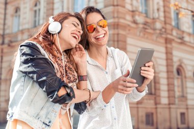 Tablet üzerinde seyir ve müzik dinleme iki güzel genç kızlar.