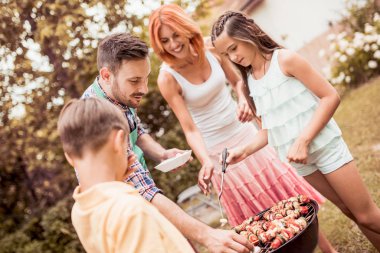 Babam arka bahçede Barbekü yapmak çocuklar öğretir, Herkes eğleniyor.