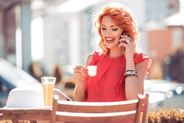 Dokunmaktan ve kahve dükkanında akıllı telefon kullanan kadın.