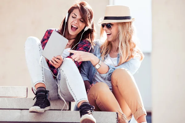 İki genç güzel kız şehirde oturan ve müzik.