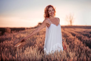 Gün batımında buğday alanında güzel Bayan.