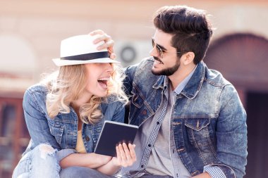 İki genç gülümseyen insanlar tablet bakıyor ve having fun.