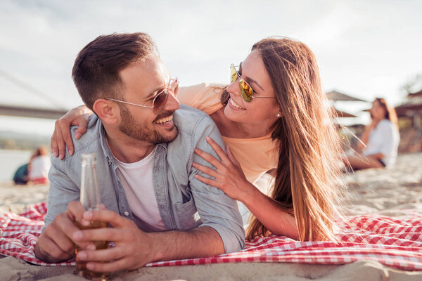 happy couple resting lying on beach